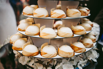 Cakes on a stand, candy bar. White chocolate covered cakes. The cakes are decorated with gold leaf.