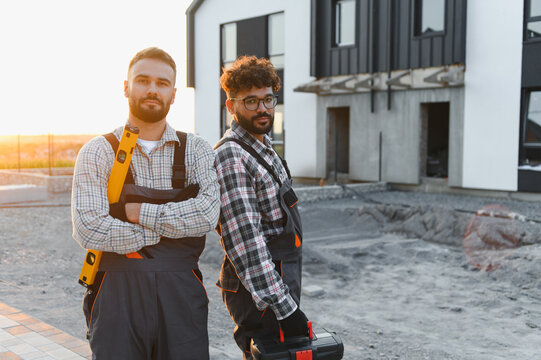 Construction workers standing together building new house