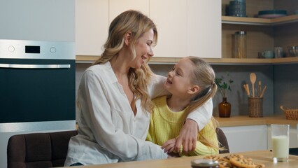 Caucasian family at kitchen hug happy little girl child kid with mother woman talking communicate...