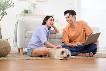 Couple Enjoys Relaxed Day Indoors With Pet Dog While Using Laptop and Smartphone in Cozy Living Room