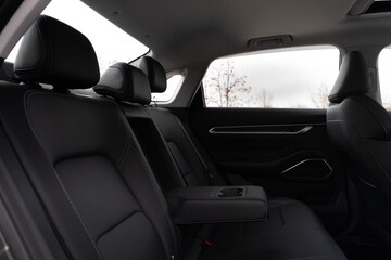 Cars passenger back rear seats armrest in black color with cup holders. Passage's seats made of genuine leather