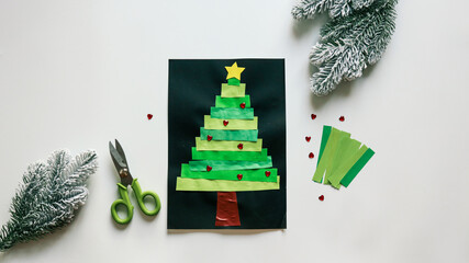 Handmade Christmas tree art with scissors and festive decorations on white background