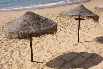 Tiki umbrellas providing shade on sandy beach