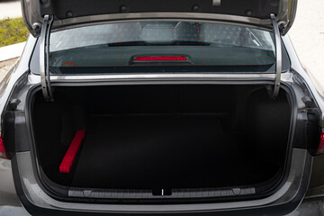 The big black empty trunk of SUV car with rubber mat and a tool box. Open luggage carrier of car closeup