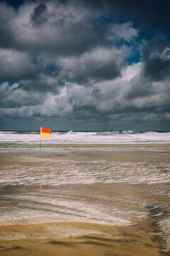 Stormy Beach with Lifeguard Flag on Windy Day, Cornwall Coast