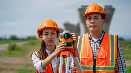 Civil engineers use surveying tools and a theodolite to measure and reference road construction plans during the ongoing project.