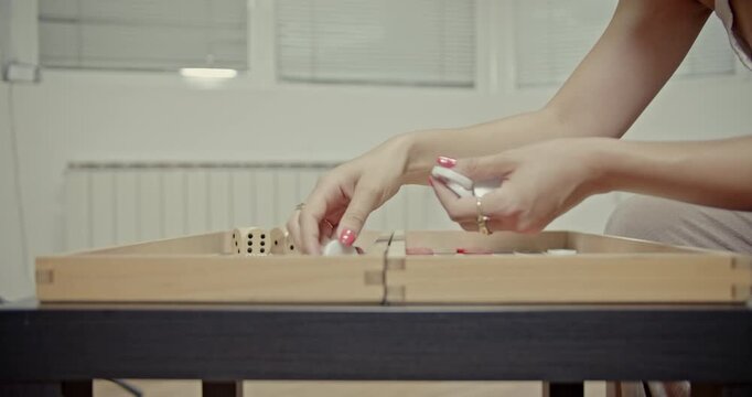 Enjoy the authentic sounds of a backgammon game as hands skillfully shake dice and move game pieces across a traditional wooden board. Perfect for illustrating leisure, strategy, and focused play.