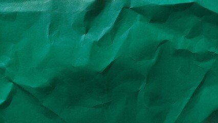 Crumpled dark green recycled paper texture. Wrinkled paper background with rough wavy pattern. Wrinkled paper background with copy space for text.