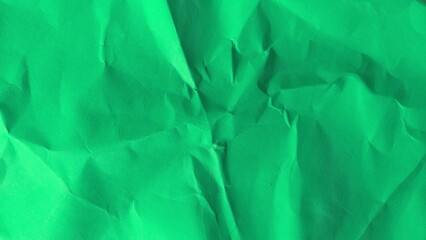 Recycled green paper with crumpled texture. Close up of wrinkled and folded green paper background.