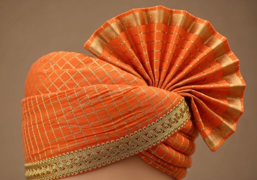 Orange pheta turban with gold trim isolated on white background