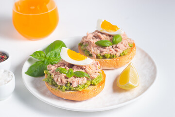 Two delicious tuna open sandwiches with avocado and boiled eggs. Tuna toast.