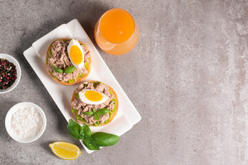 Two delicious tuna open sandwiches with avocado and boiled eggs. Tuna toast.
