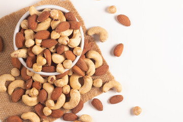 Large assortment of nuts in different bowls on stone table