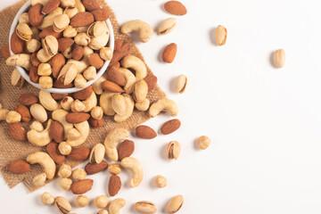 Large assortment of nuts in different bowls on stone table