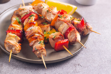 Delicious grilled chicken skewers with capsicum, lemon, salad and ketchup on a plate over the table. Chicken kebab. Healthy food concept.