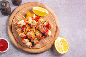 Delicious grilled chicken skewers with capsicum, lemon, salad and ketchup on a plate over the table. Chicken kebab. Healthy food concept.