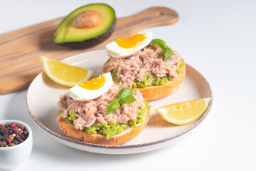 Two delicious tuna open sandwiches with avocado and boiled eggs. Tuna toast.