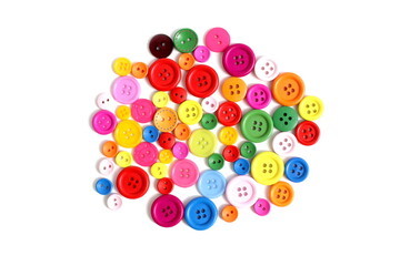 There are many multi-colored buttons on a white background.	