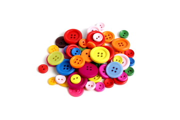 There are many multi-colored buttons on a white background.	