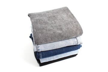 There is a stack of folded jeans on a white background.	
