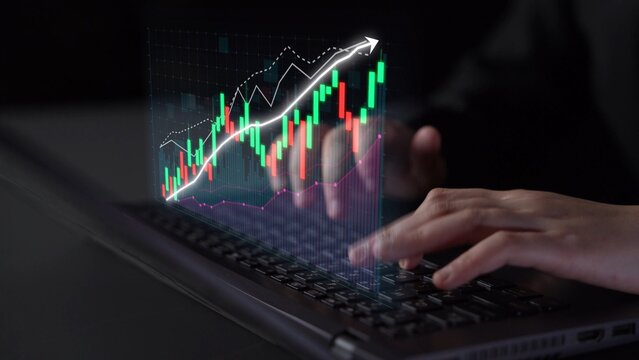 A focused scene of hands typing on a laptop, showcasing a dynamic financial chart with upward trends, symbolizing investment growth and digital finance innovation. Copula