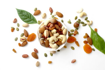 There is a white bowl with different nuts on a white background.	