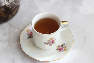 A cup of herbal tea stands on a light table
