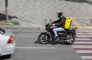 Abstract image of a courier on a motorcycle on a blurred background