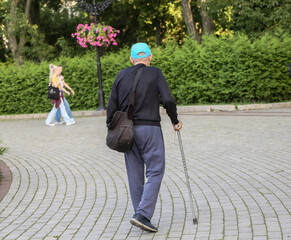 An elderly man with a cane in a city park
