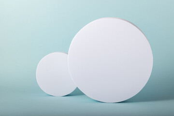 Minimal concept with two white round stands on blue background. Mock up.