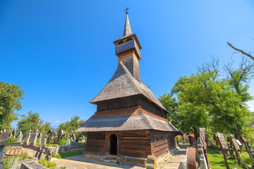 Leud Hill Church, an ancient UNESCO wooden Orthodox church, standing among tombs in the historic Maramures region of Romania