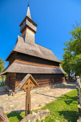 Famous UNESCO wooden church of Leud Deal, Maramures, Romania, showcasing traditional Orthodox architecture and history under blue sky