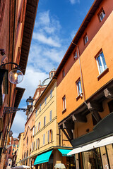 Medieval street in Bologna, with the distinctive architecture. The warm, orange buildings and detailed wooden structures capture the charm of this historic area.Bologna, Province of Ferrara, Italy