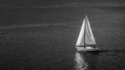 A lone sailboat glides gracefully over serene waters captured in quiet elegance.