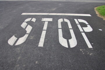 stop sign painted on asphalt