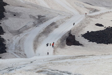 Fototapeta premium A chain of climbers ascending Mount Elbrus from a height of 4,100 m.