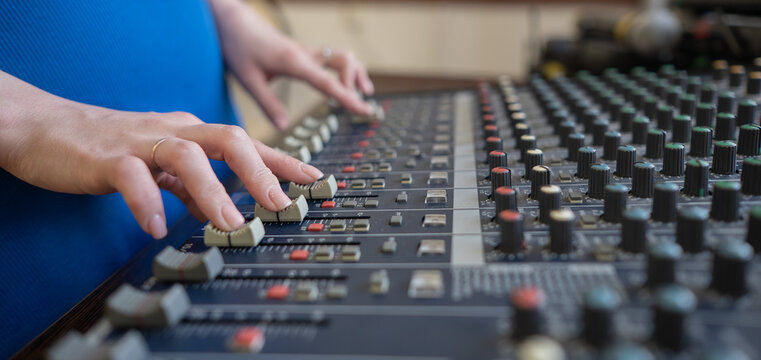 Hands Adjusting Sound Levels on Mixing Console.  - Powered by Adobe