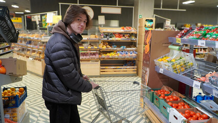 Young man buying groceries at the supermarket.