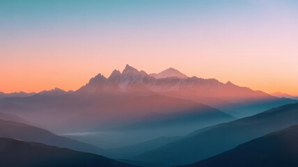 Jagged mountain peaks at dawn with soft orange and blue sky sunrise