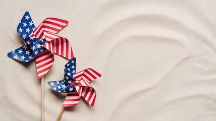 Two american flag pinwheels on a sandy beach, symbolizing patriotism and summer fun