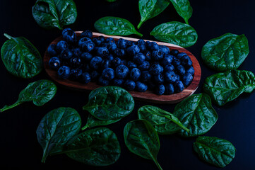 grapes berries spinach on a black background