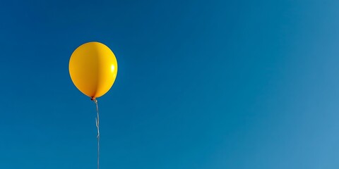 Bright Yellow Balloon Floating in Vast Blue Sky Minimal Concept
