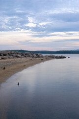 Beautiful atmospheric sunset with warm orange and pink hues, illuminating the sky and landscape in soft glowing light.
