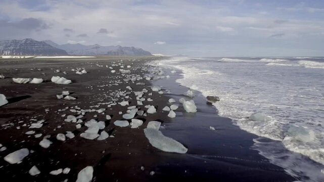 Aerial view of black sand beach with iceberg ice pieces on the shore also called diamond beach