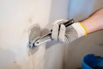 Demonstrating the skilled trade of wall repair, showing the application of a fast-setting compound to fix structural damage.