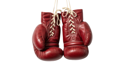 Vintage red leather boxing gloves hanging by their white laces isolated on transparent background