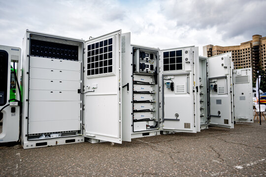 Ukraine, Kyiv - October, 16, 2025:Modular battery energy storage systems and power electronics, open to reveal "Deye" components, outdoors on asphalt under a cloudy sky.