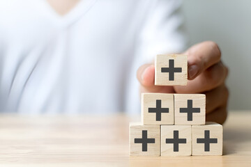 Positive things; added value, benefits, additional, personal development, growth mindset, positive thinking, opportunities, emerging market. Putting the cubes with plus sign to offer positive things.