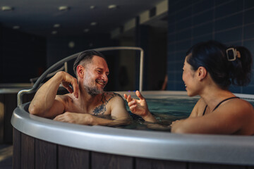 Couple relaxing in hot tub enjoying wellness spa treatment