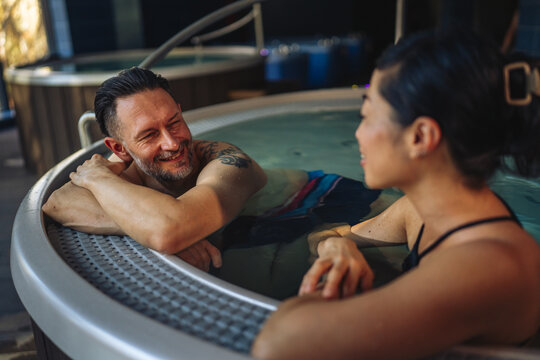 Couple relaxing in hot tub enjoying wellness spa treatment